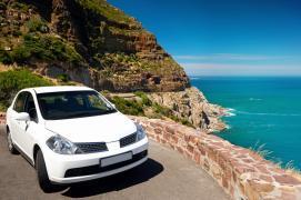 Car parked along a sunny coastal road in Spain during a holiday trip