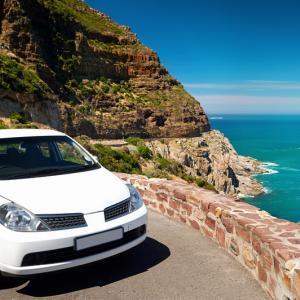 Car parked along a sunny coastal road in Spain during a holiday trip