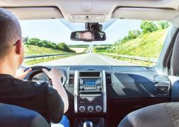 Man driving a car rental on an Irish road in Ireland.